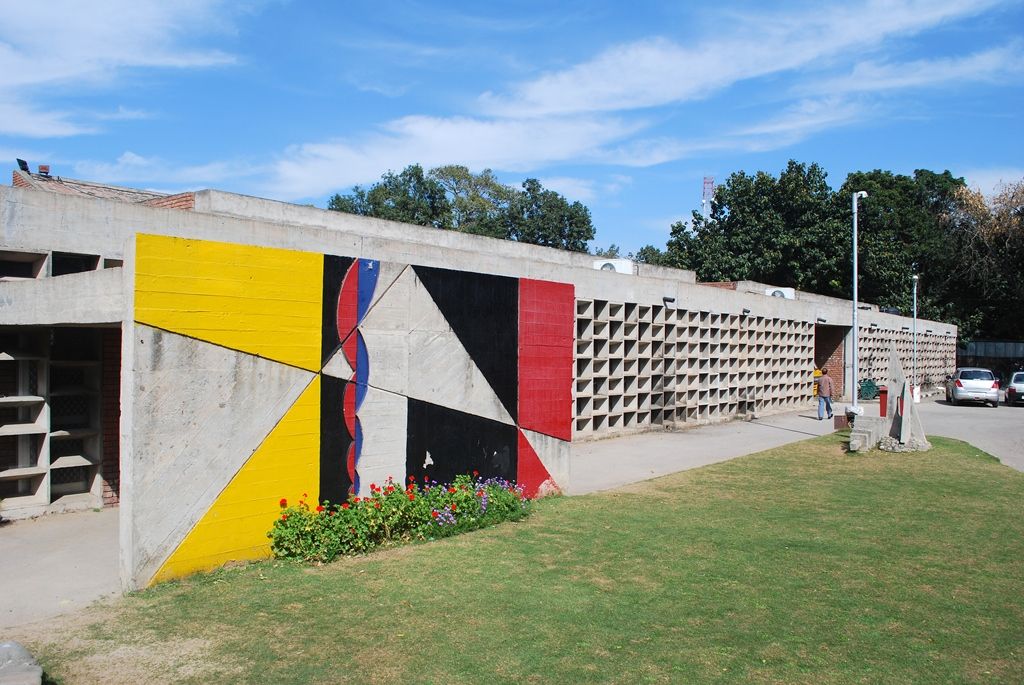 Front facade of Chandigarh College of Architecture, with a painted mural panel and concrete screen wall.